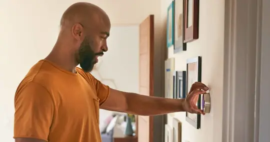 person adjusting thermostat settings